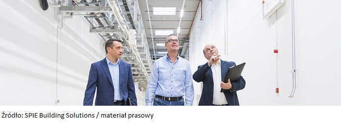 Three businessmen inspecting corridor in factory