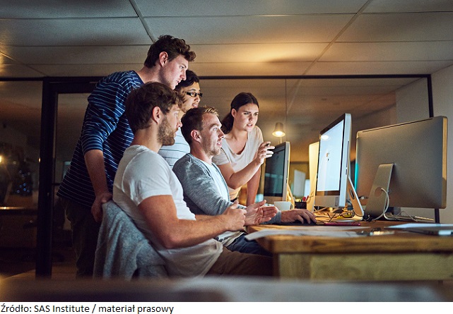 Shot of a group of young people using a computer together during a late night in a modern office